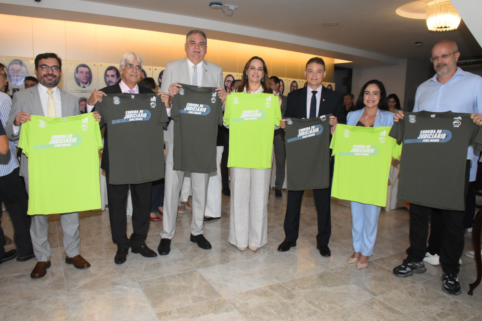 Foto do presidente do TJ e auxiliares exibindo a camisa da corrida